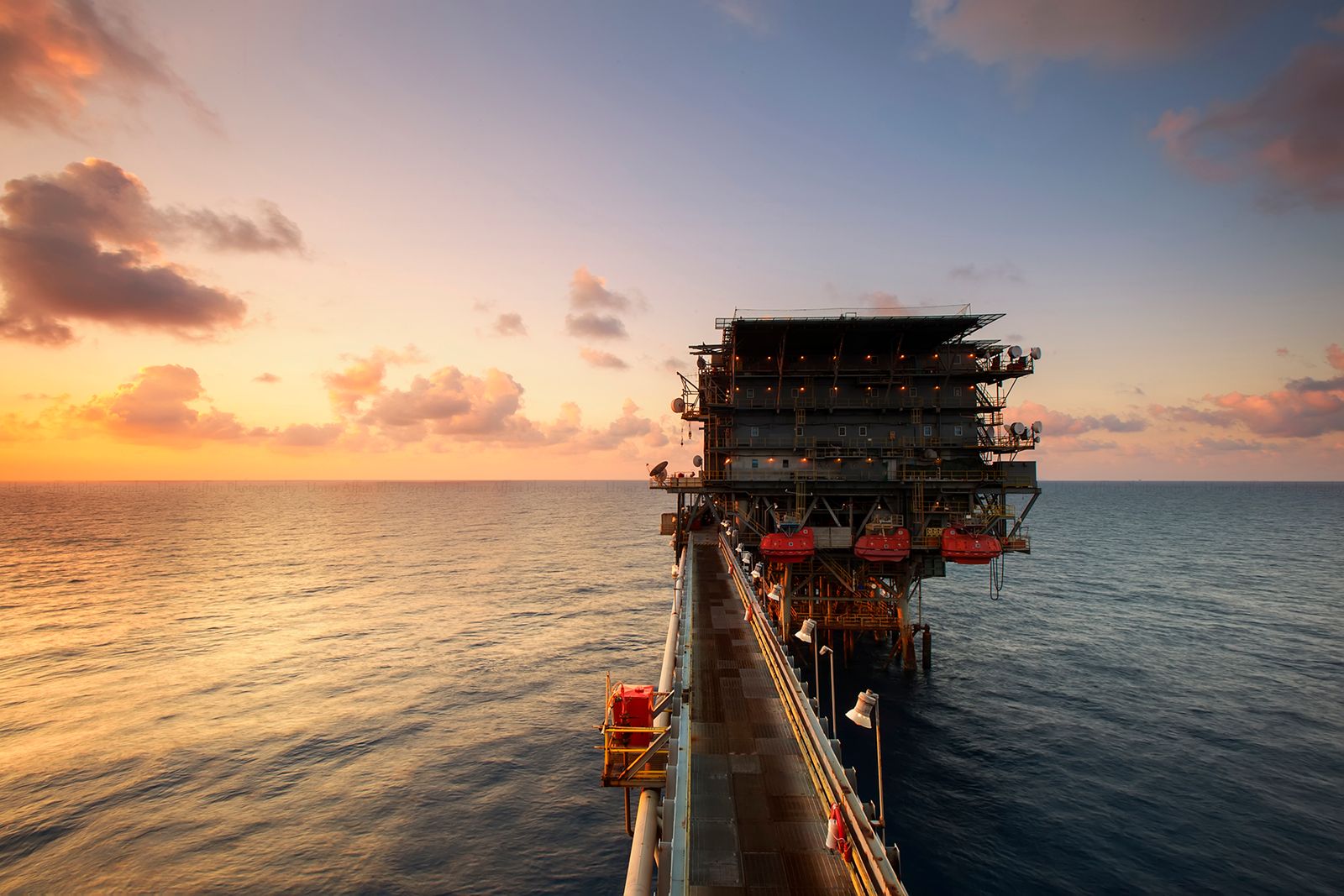 An offshore oil and gas platform at sunset